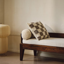 Load image into Gallery viewer, Lifestyle shot of cream and beige wool bouclé checkered square cushion on daybed